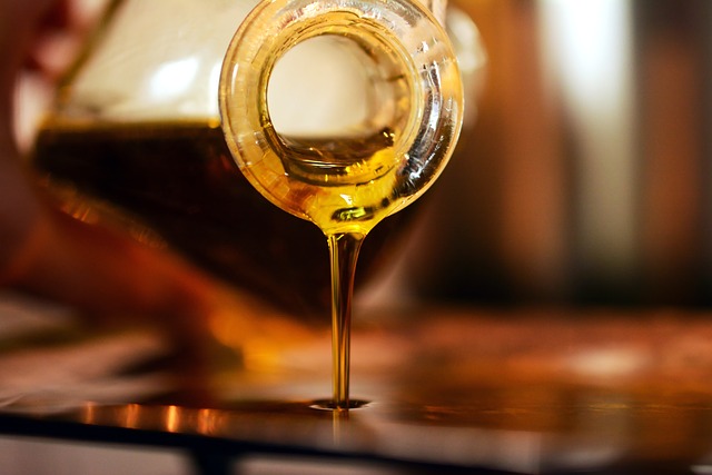 Cooking oil being poured from glass bottle